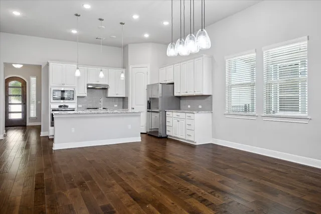 a kitchen with stainless steel appliances a refrigerator sink and cabinets