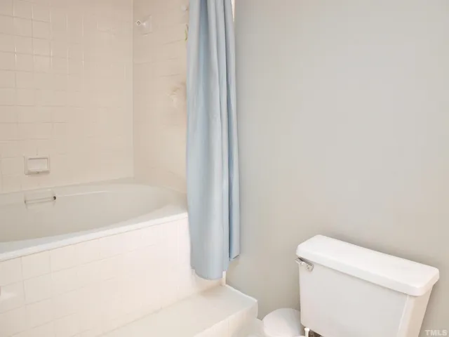a white bath tub sitting next to a toilet