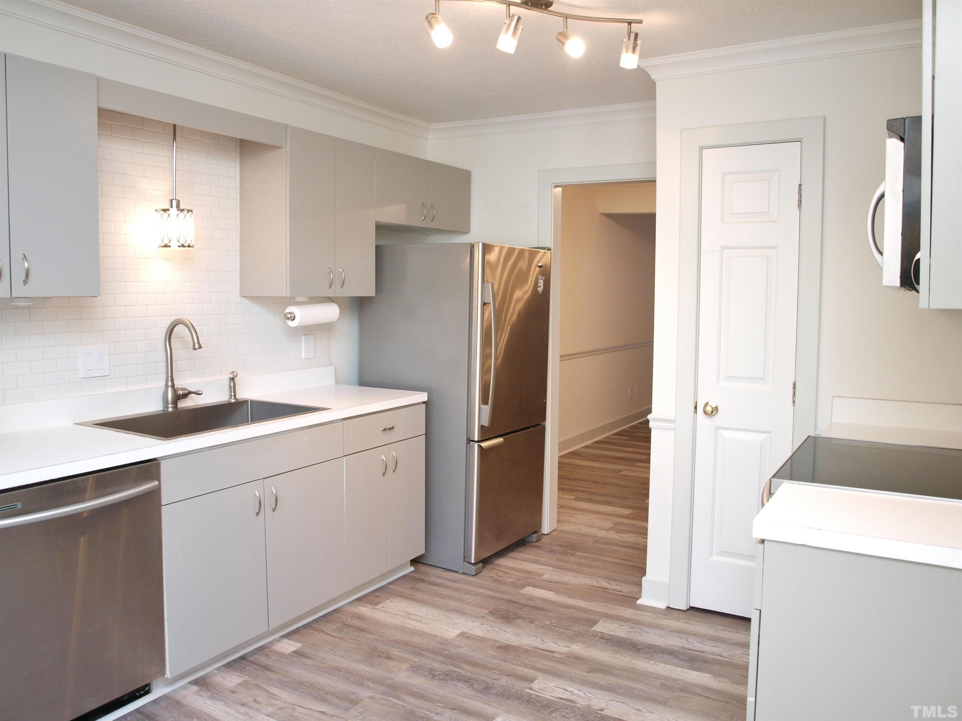 1424 Quarter Point Raleigh, NC 27615 - Photo 4 of 18 a kitchen with a sink refrigerator and cabinets