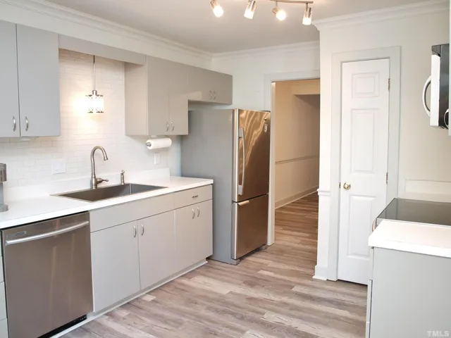 a kitchen with a refrigerator sink and cabinets