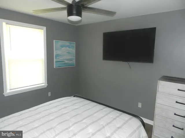 a bedroom with a bed and a flat tv screen