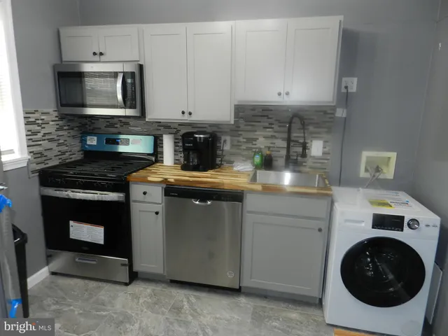 a kitchen with granite countertop white cabinets stainless steel appliances and sink