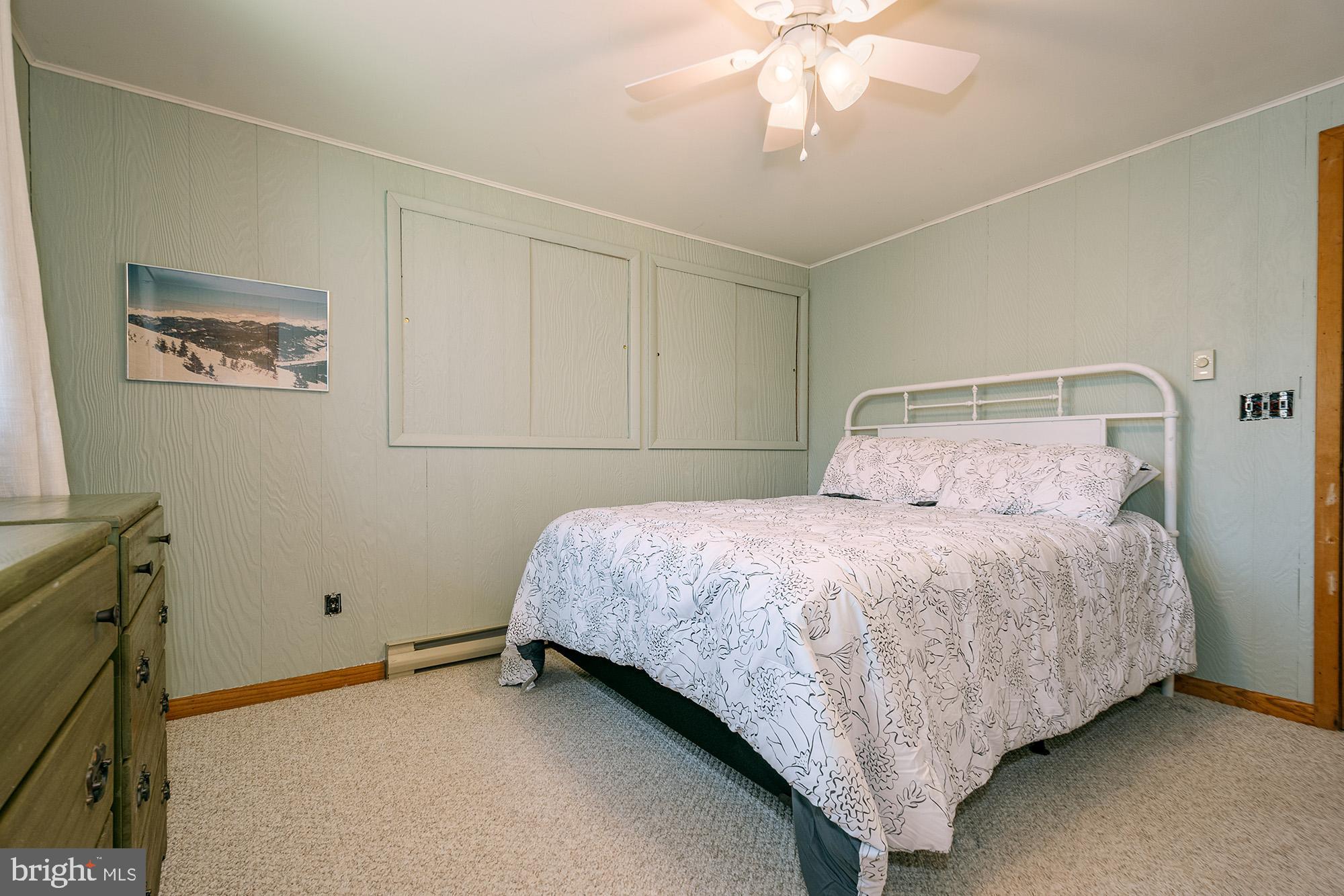 1723 Marsh Hill Road McHenry, MD 21541 - Photo 12 of 40 a bedroom with a bed and a chandelier