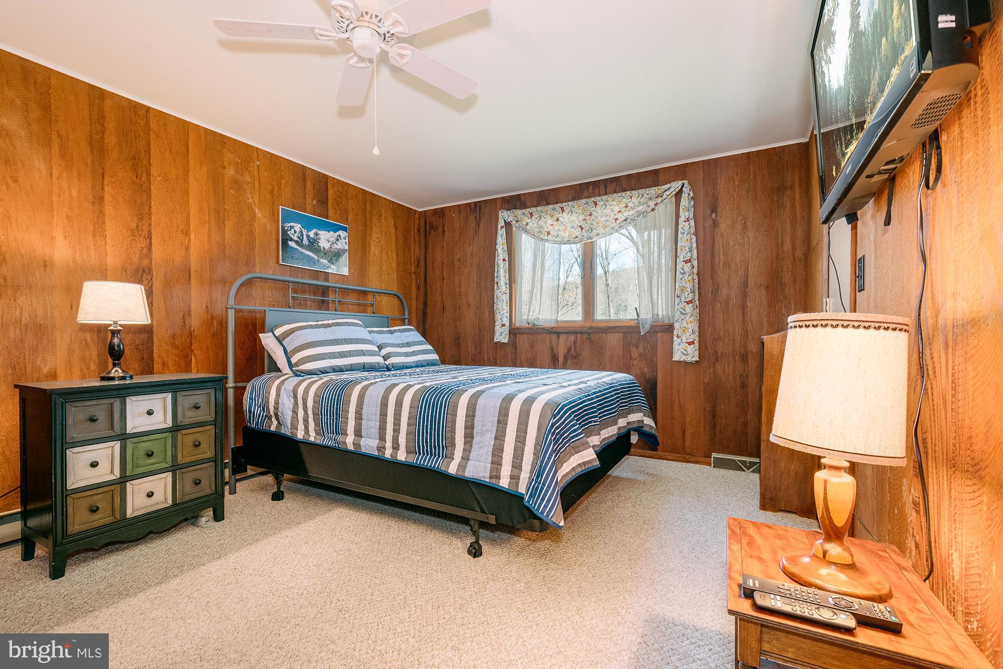 1723 Marsh Hill Road McHenry, MD 21541 - Photo 10 of 40 a bedroom with a bed and a dresser next to a window
