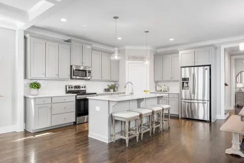 a kitchen with white cabinets and stainless steel appliances