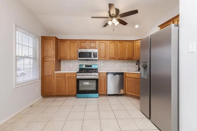 a kitchen with a refrigerator a sink and cabinets