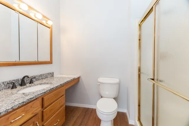 a bathroom with a granite countertop sink toilet and a mirror
