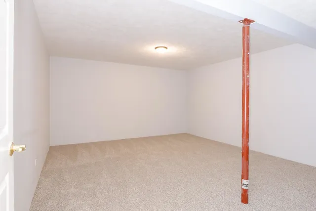 an empty room with wooden floor and fan