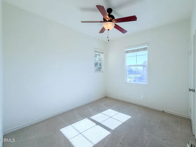 an empty room with closet and a chandelier fan
