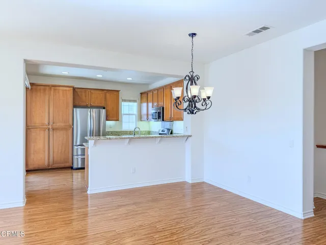 a view of kitchen with stainless steel appliances granite countertop cabinets and wooden floor