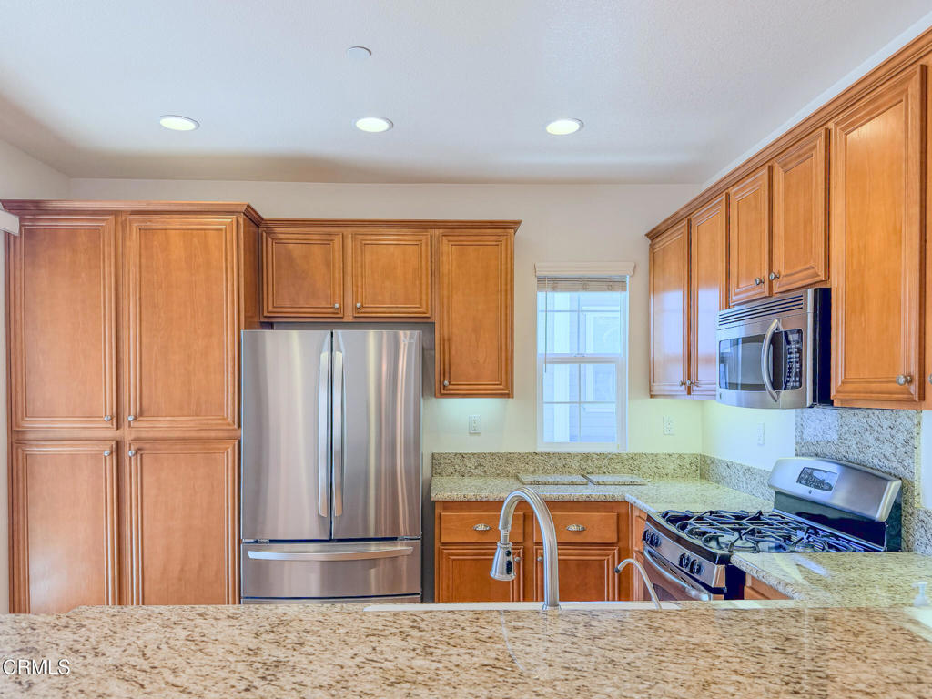 8262 Onyx Street Ventura, CA 93004 - Photo 10 of 33 a kitchen with stainless steel appliances granite countertop a refrigerator and a sink