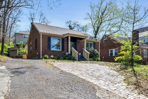 a front view of a house with a yard and potted plants