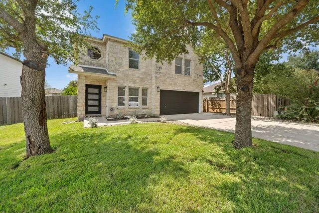 a view of a house with backyard and a tree