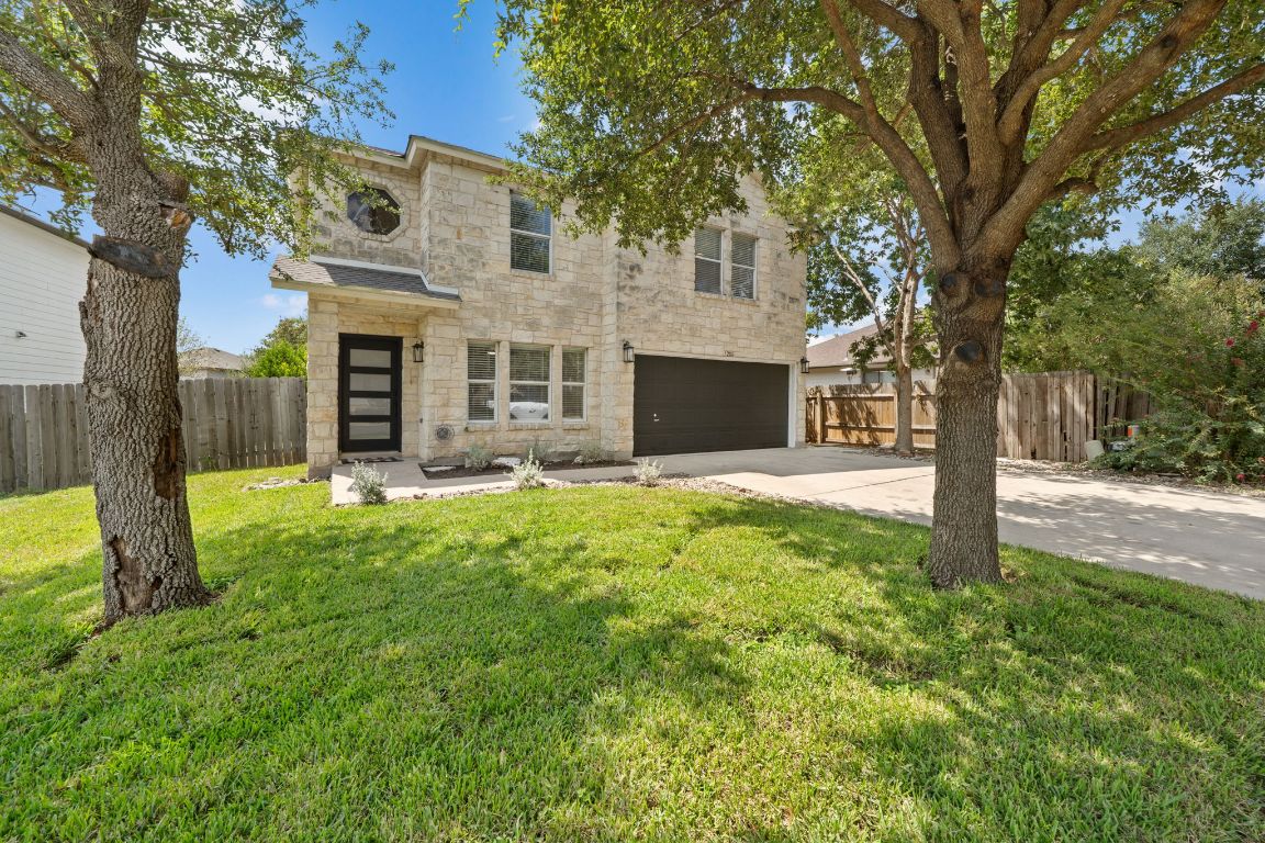 a view of a house with backyard and a tree