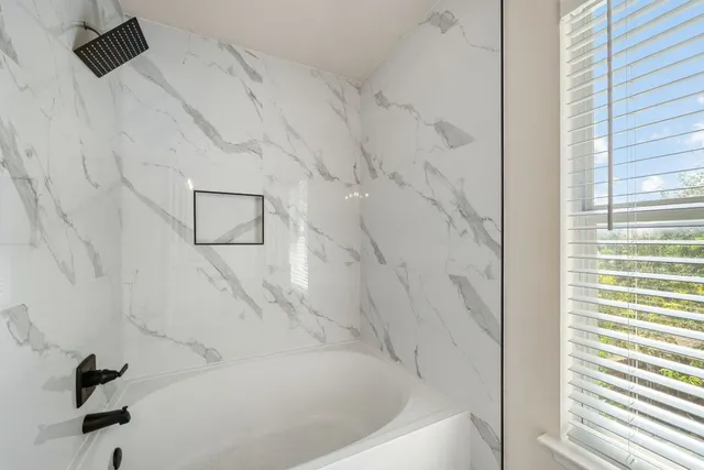 a white bath tub sitting next to a shower