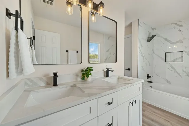 a bathroom with a sink and a mirror a bathtub