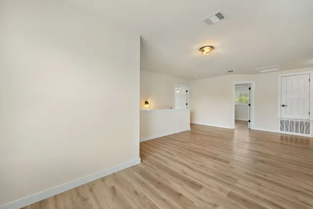 a view of an empty room with wooden floor