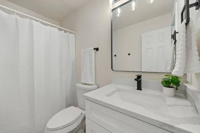 a bathroom with a sink a toilet and a mirror