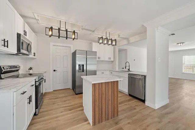 a kitchen with cabinets and wooden floor