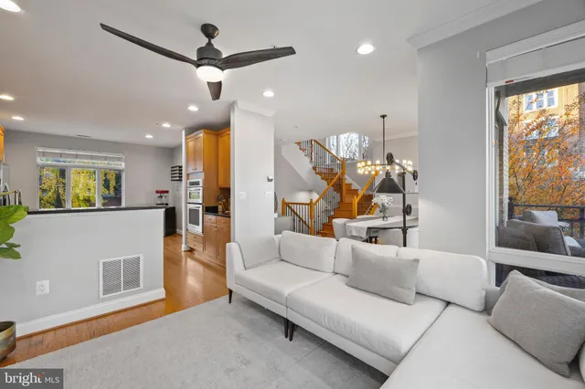 a living room with furniture a flat screen tv and a floor to ceiling window
