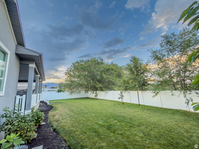 3269 West 650 North Layton, UT 84041 - Photo 28 of 35 Expansive backyard featuring a manicured lawn, white privacy fencing, and mature perimeter trees