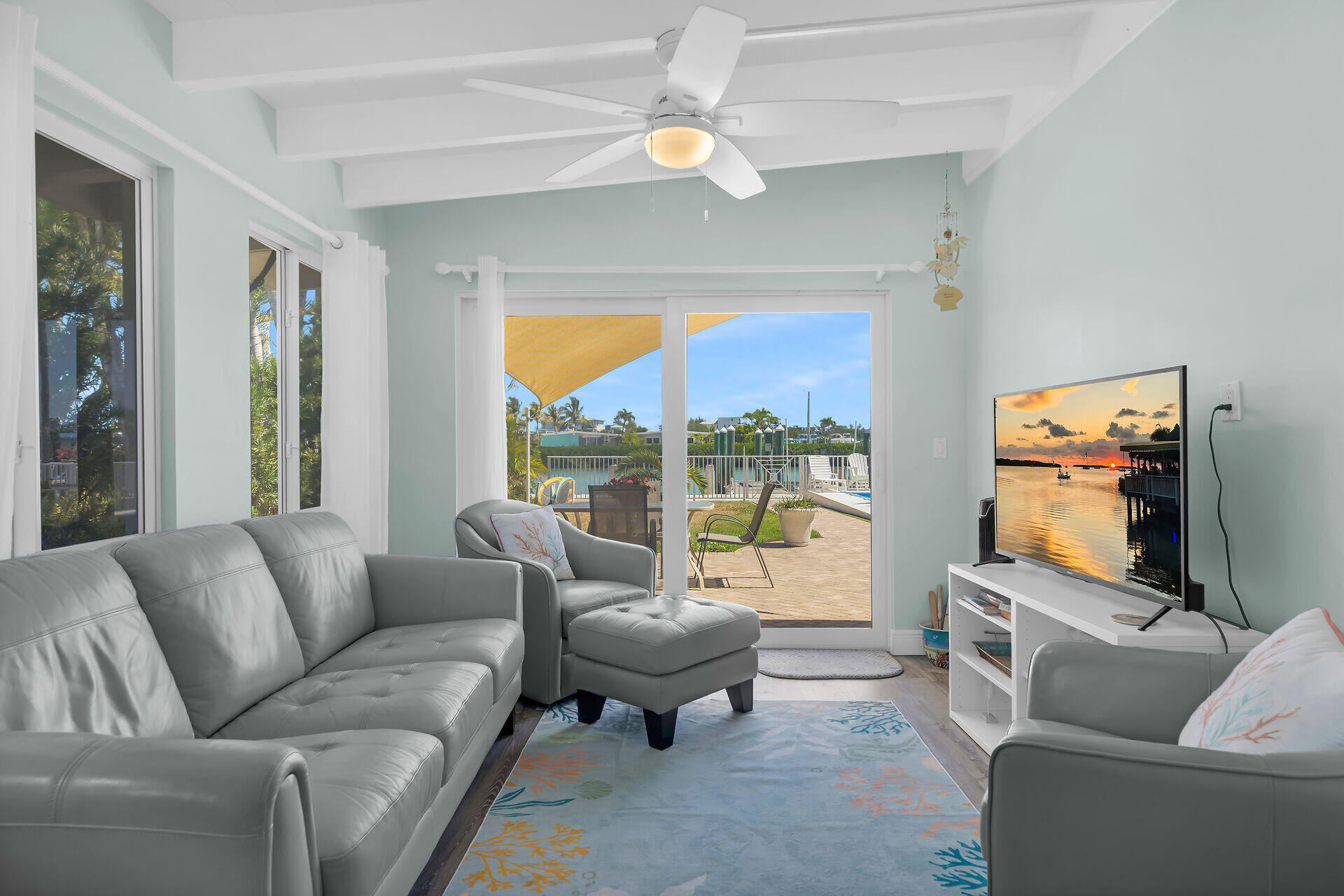 70 7th Street Key Colony Beach, FL 33051 - Photo 12 of 46 a living room with furniture a ceiling fan and a flat screen tv