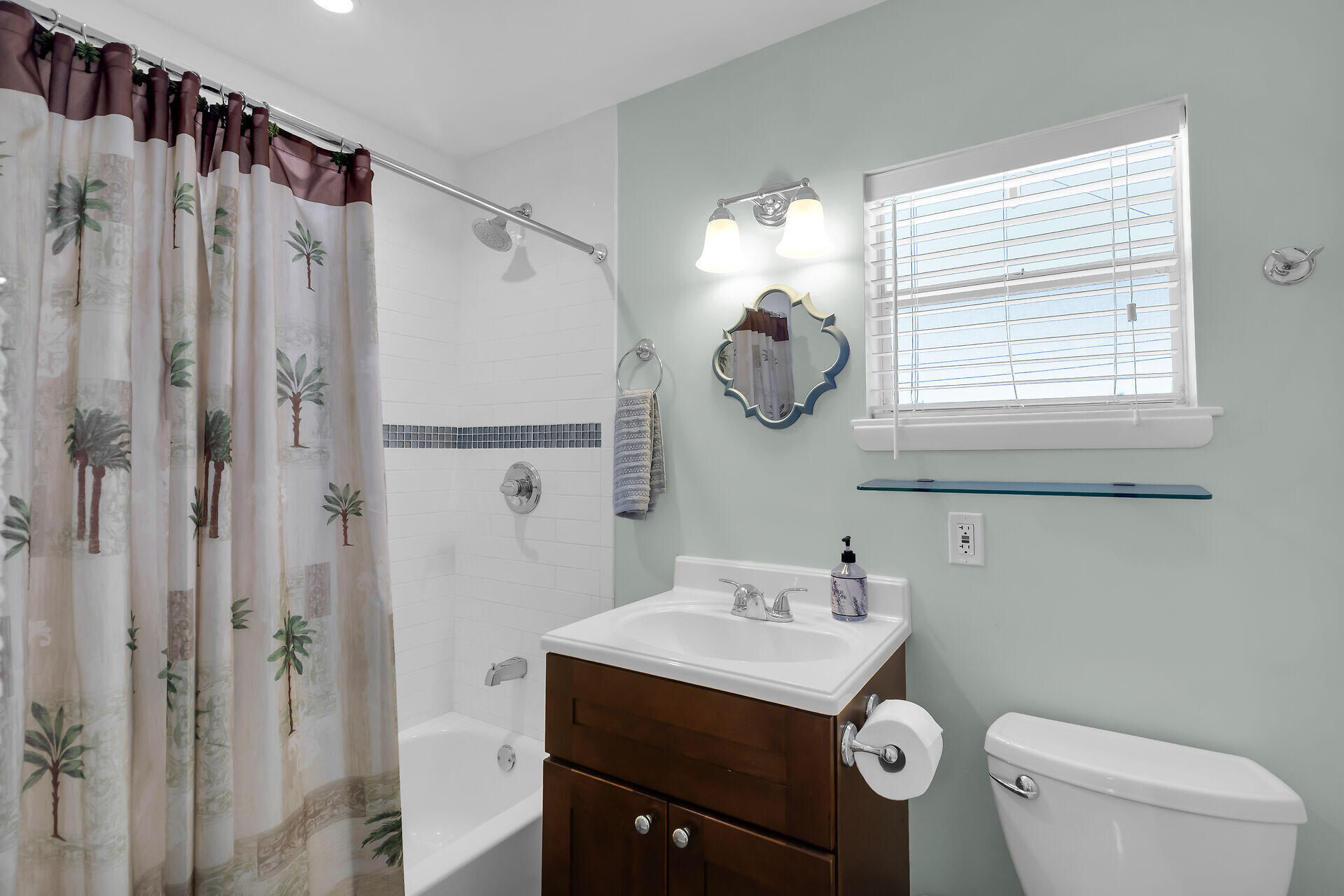 70 7th Street Key Colony Beach, FL 33051 - Photo 19 of 46 a bathroom with a sink a mirror a toilet and a window