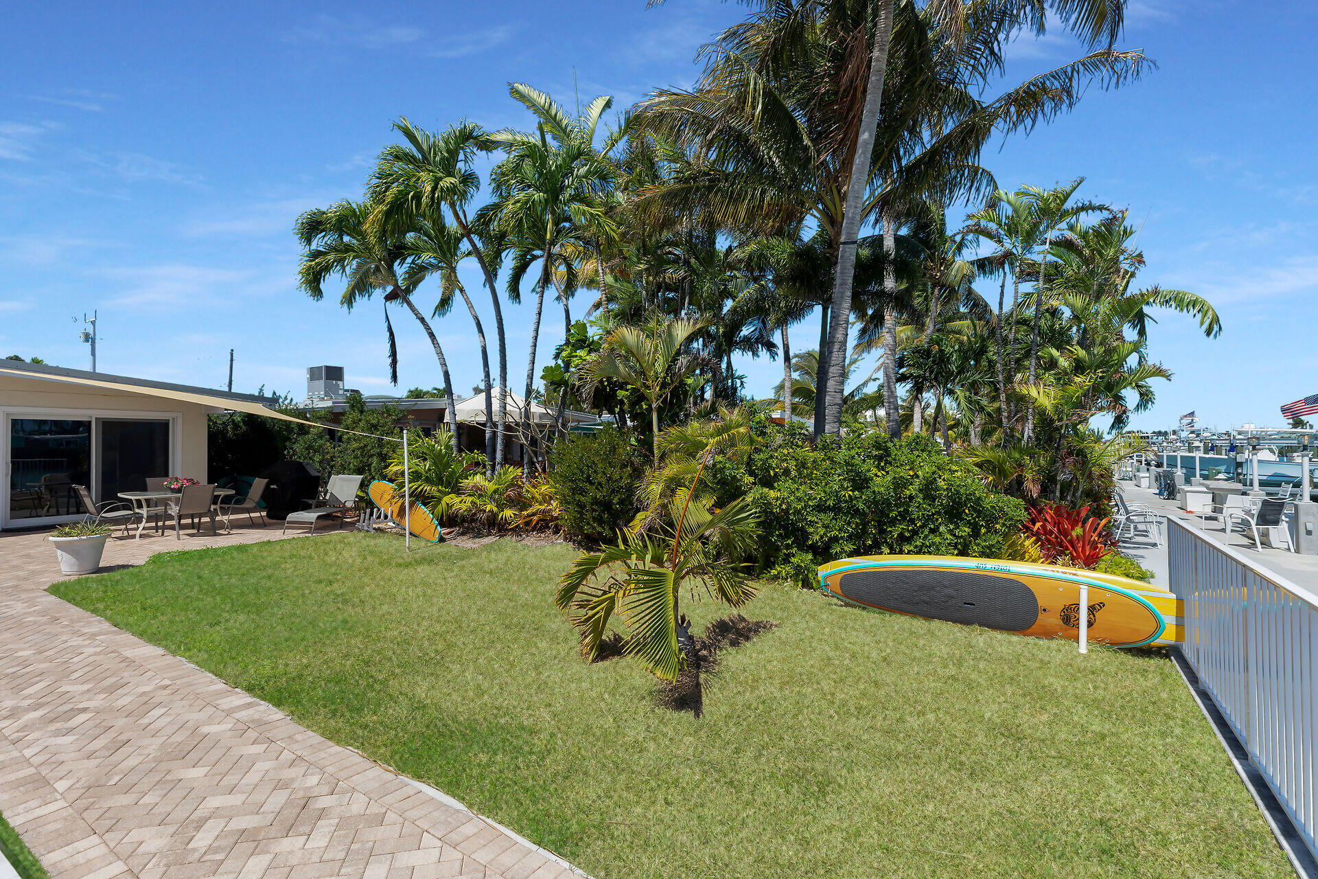 70 7th Street Key Colony Beach, FL 33051 - Photo 29 of 46 a backyard of a house with table and chairs plants and large tree