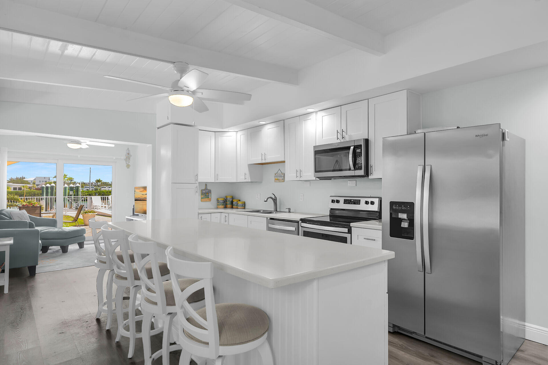 70 7th Street Key Colony Beach, FL 33051 - Photo 6 of 46 a kitchen with stainless steel appliances granite countertop a refrigerator a stove a sink a dining table and chairs with wooden floor