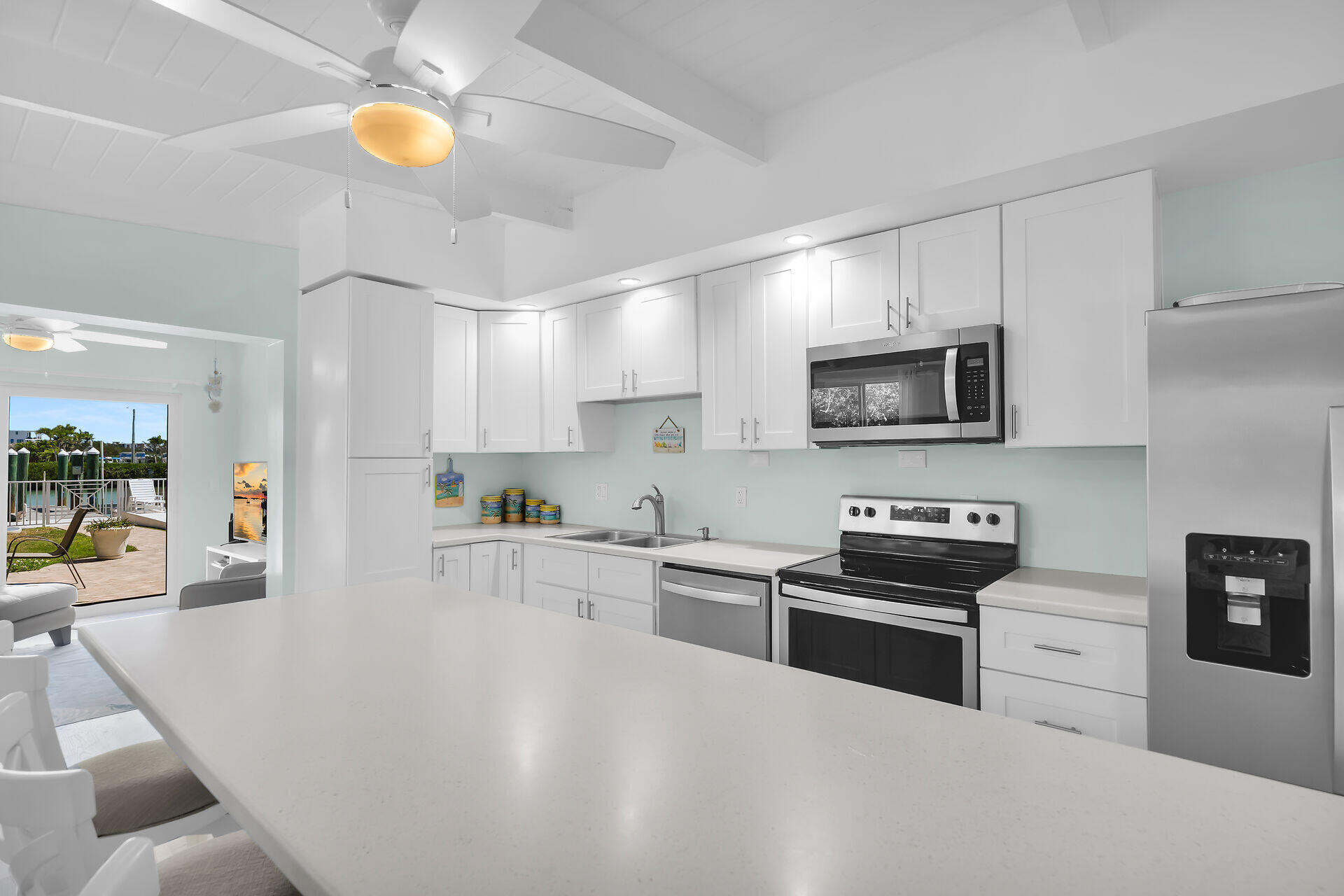 70 7th Street Key Colony Beach, FL 33051 - Photo 7 of 46 a kitchen with stainless steel appliances a stove sink microwave and cabinets