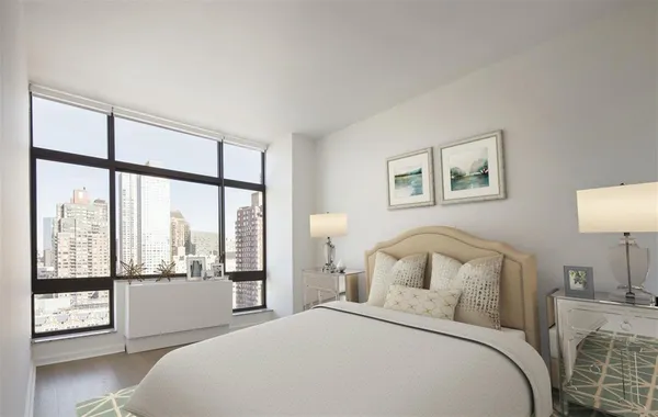 a bedroom with a large bed and a large window