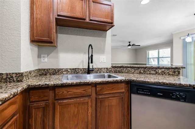 a kitchen with granite countertop a sink and cabinets