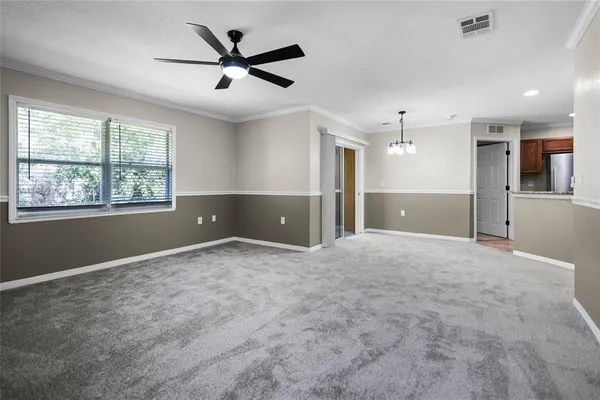 a view of a livingroom with a ceiling fan and window