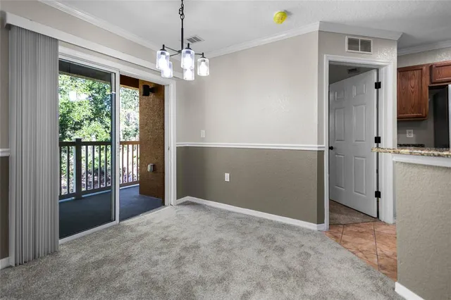 a view of a livingroom with a chandelier fan and a kitchen