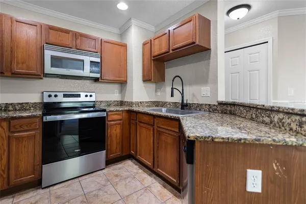 a kitchen with granite countertop a sink and a stove top oven