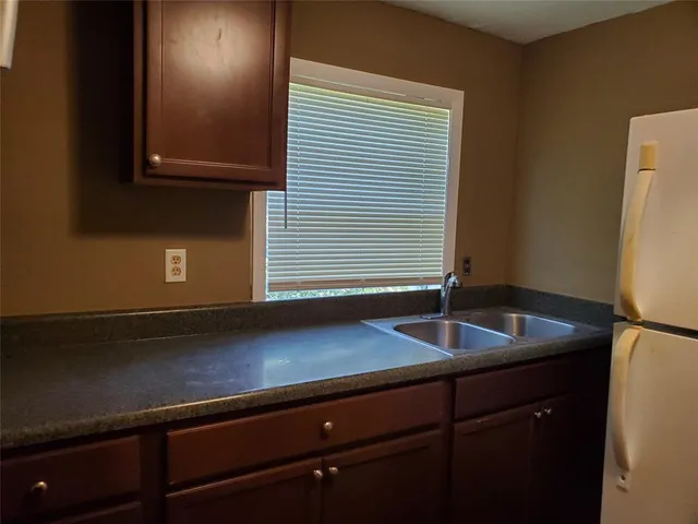 a kitchen with a sink and wooden floor