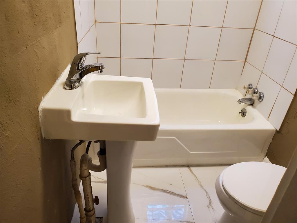 258 Adams Place, Unit 2 Pahokee, FL 33476 - Photo 18 of 25 a bathroom with a sink a toilet and bathtub