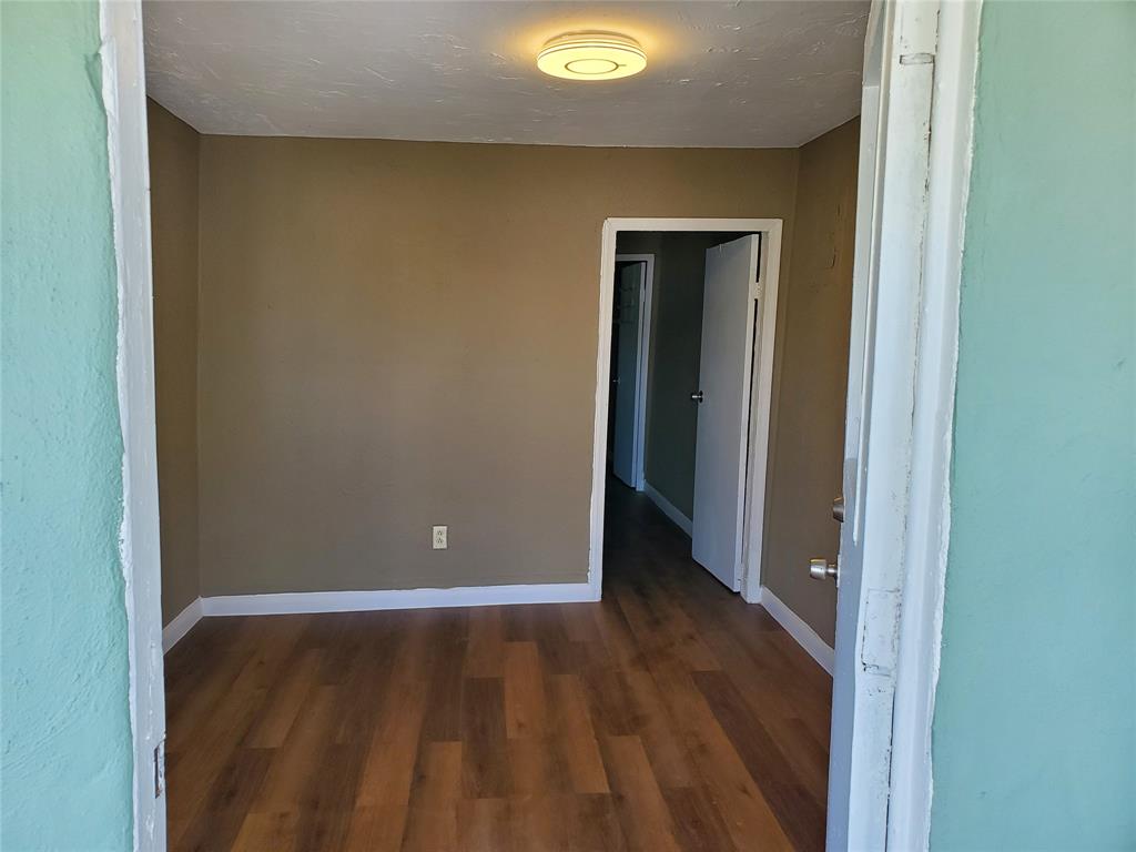 258 Adams Place, Unit 2 Pahokee, FL 33476 - Photo 22 of 25 a view of an empty room with wooden floor and closet