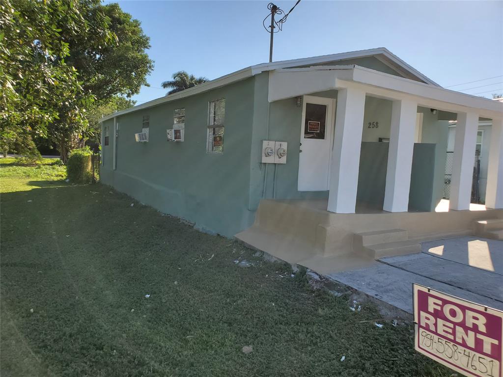 258 Adams Place, Unit 2 Pahokee, FL 33476 - Photo 4 of 25 a front view of a house with garden