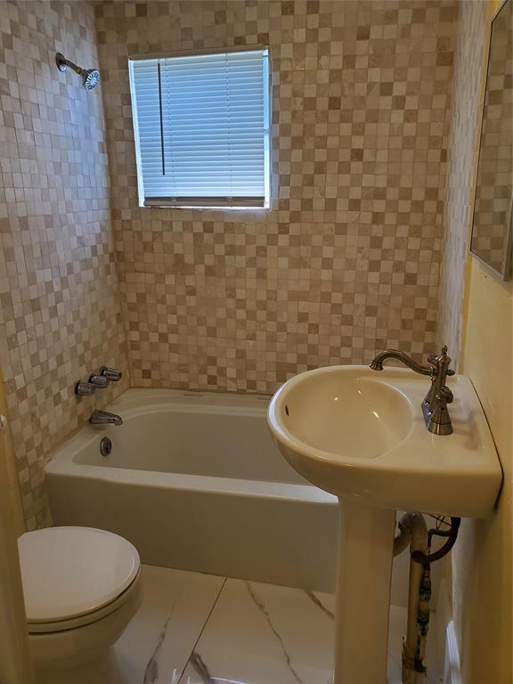 258 Adams Place, Unit 2 Pahokee, FL 33476 - Photo 8 of 25 a bathroom with a sink a toilet and bathtub