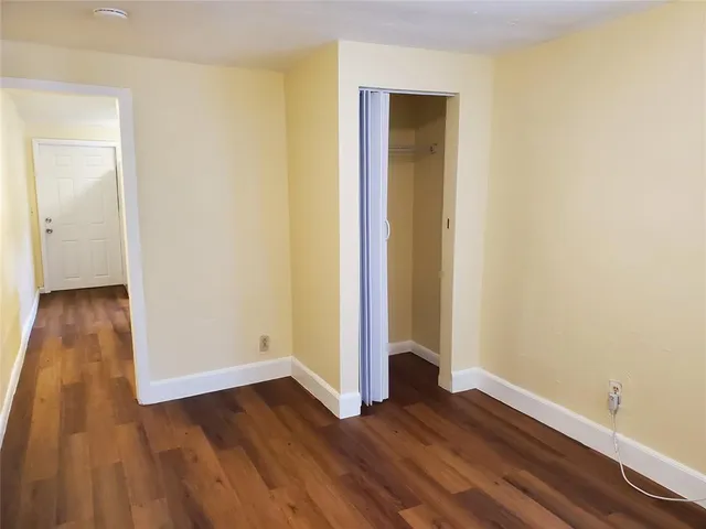 an empty room with wooden floor and entrance