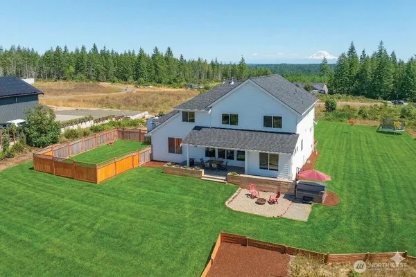 a front view of house with yard and trees in the background