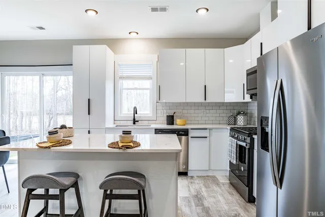 a kitchen with white cabinets and stainless steel appliances
