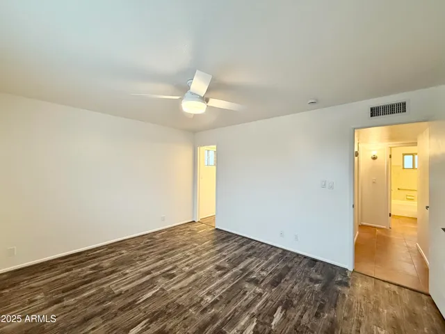 an empty room with a window and ceiling fan