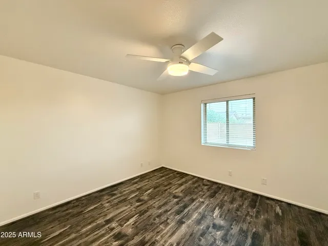 a view of a room with a ceiling fan and a window