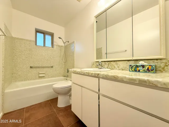 a spacious bathroom with a toilet sink and a mirror