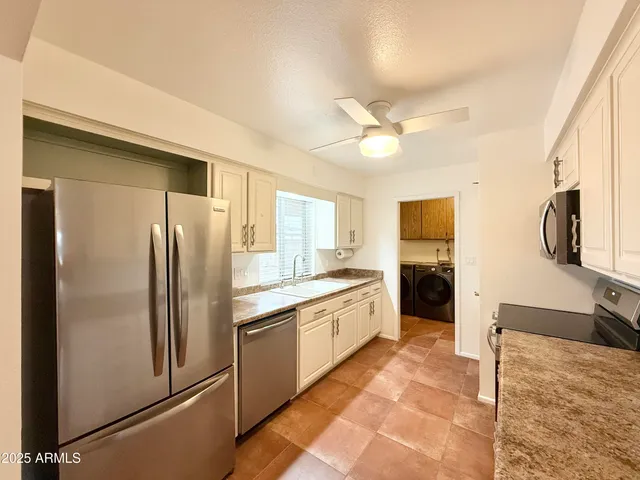 a kitchen with stainless steel appliances granite countertop a refrigerator and a stove top oven