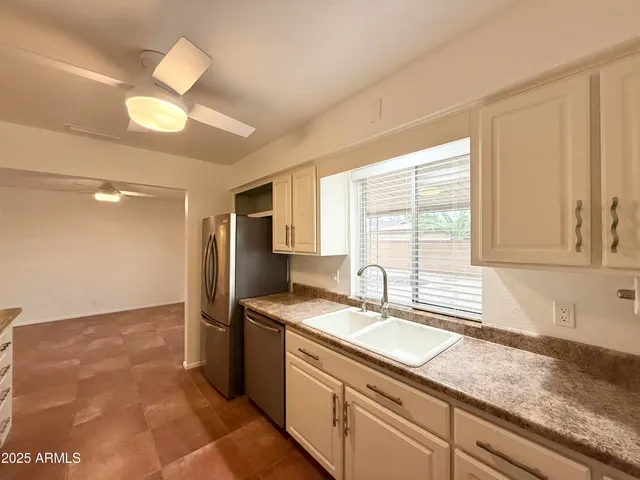 a kitchen with granite countertop white cabinets and stainless steel appliances