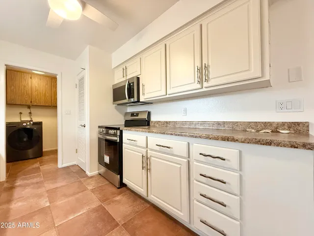a view of a livingroom with wooden floor and kitchen space with a sink