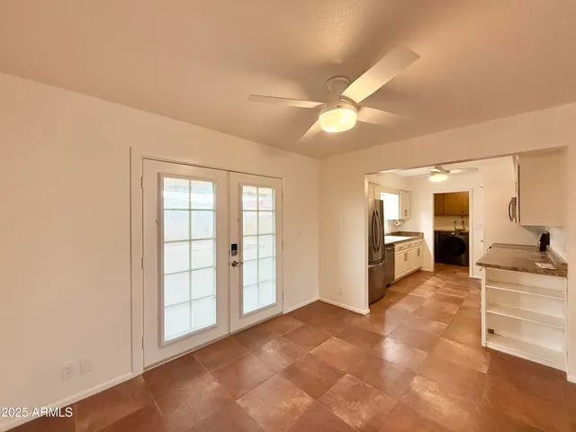 an empty room with windows and fan